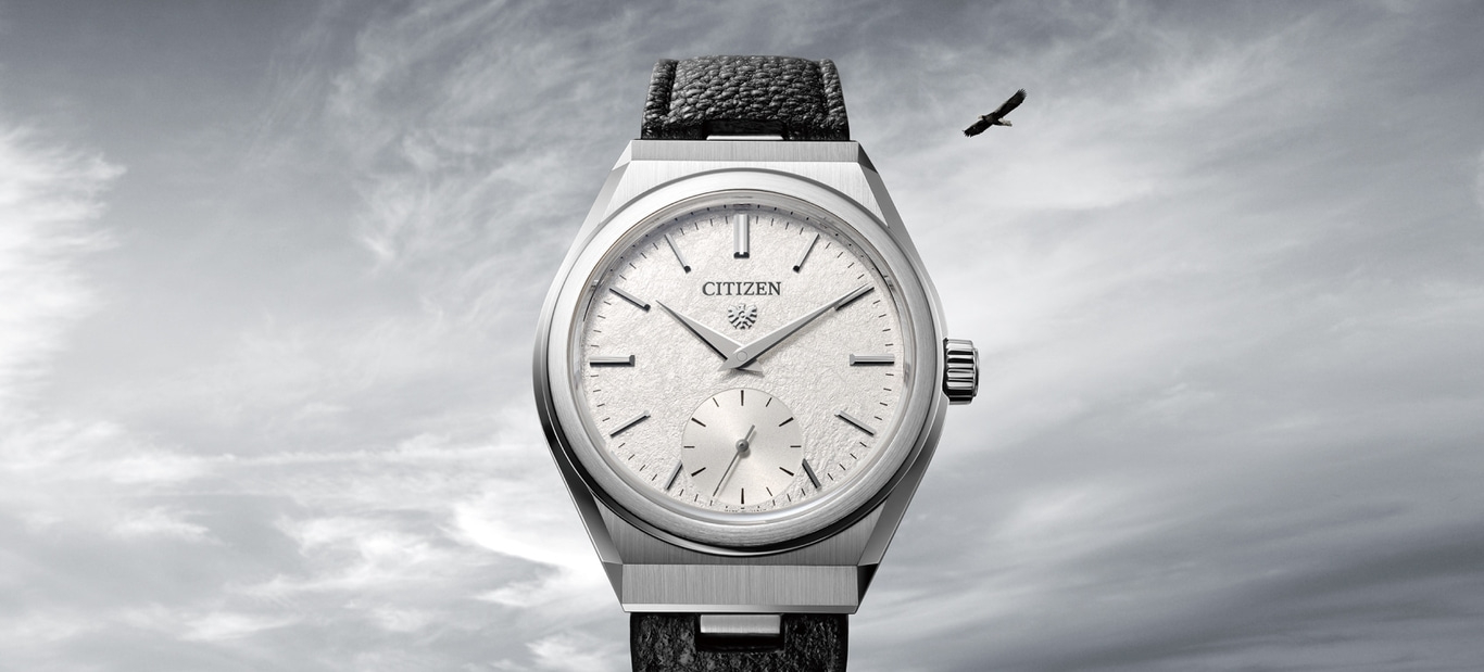 Citizen horloge met leren band tegen een bewolkte lucht en een vogel.