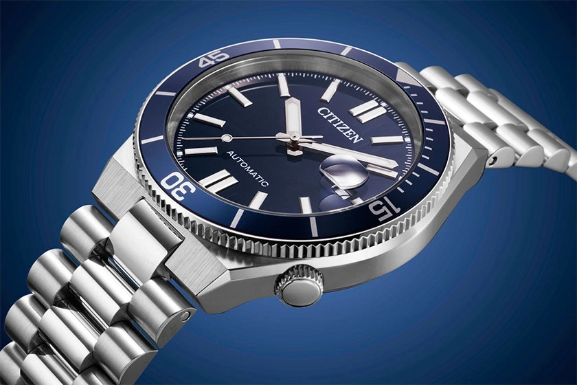 Close-up van een Citizen automatisch horloge met blauwe wijzerplaat en zilveren band.
