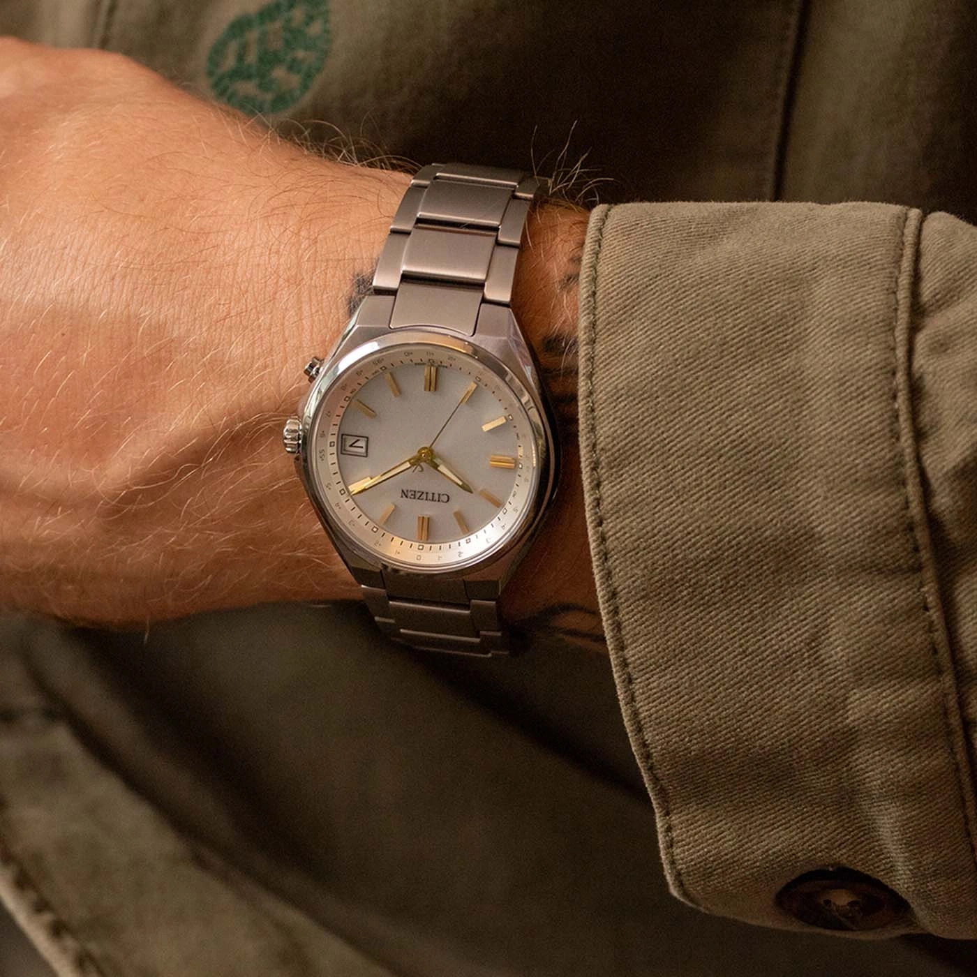 Herenhorloge om de pols, merk Citizen, zilveren band en lichte wijzerplaat.
