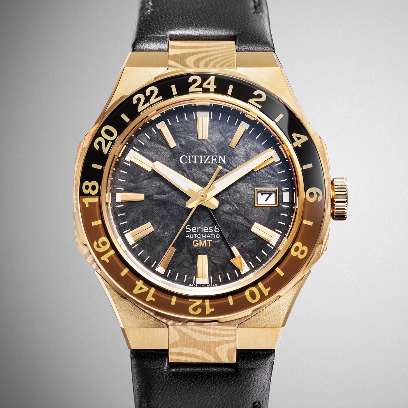 Een gouden Citizen Series8 Automatic GMT horloge met een zwarte wijzerplaat en een zwarte leren band.