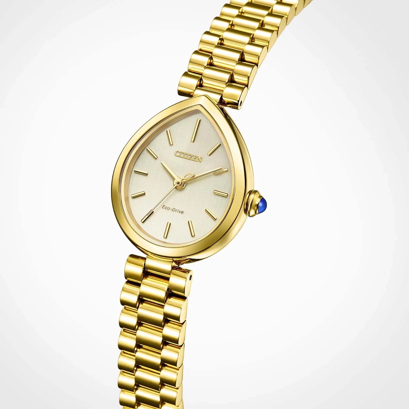 Een close-up studioportret van een gouden Citizen Eco-Drive horloge met een druppelvormige wijzerplaat en een blauwe edelsteen op de kroon.