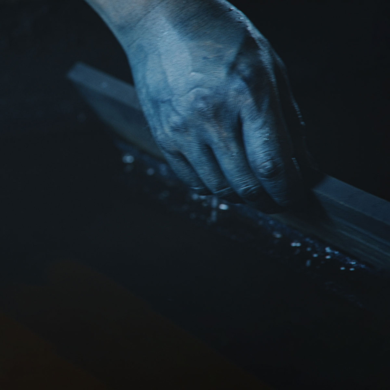 Hand hält dunkles Objekt, Blautöne, Nahaufnahme, geheimnisvoll, künstlerisch, stimmungsvoll, dunkler Hintergrund