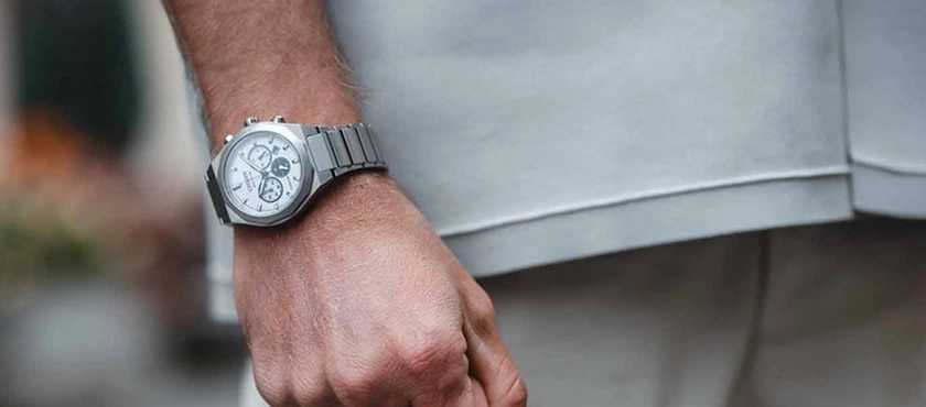 Pols van een man met een zilveren chronograaf horloge
