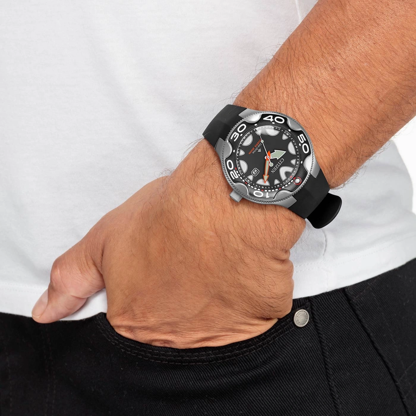 Man met Citizen horloge, zwarte band, in zak, zwarte jeans, wit shirt.