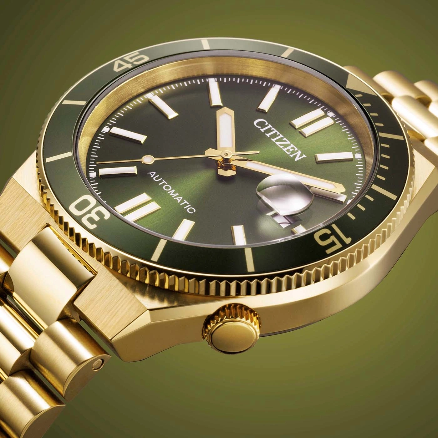 Close-up van een gouden Citizen automatische horloge met groene wijzerplaat en lunette.