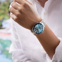 Man draagt een blauw Citizen automatisch horloge om zijn pols.