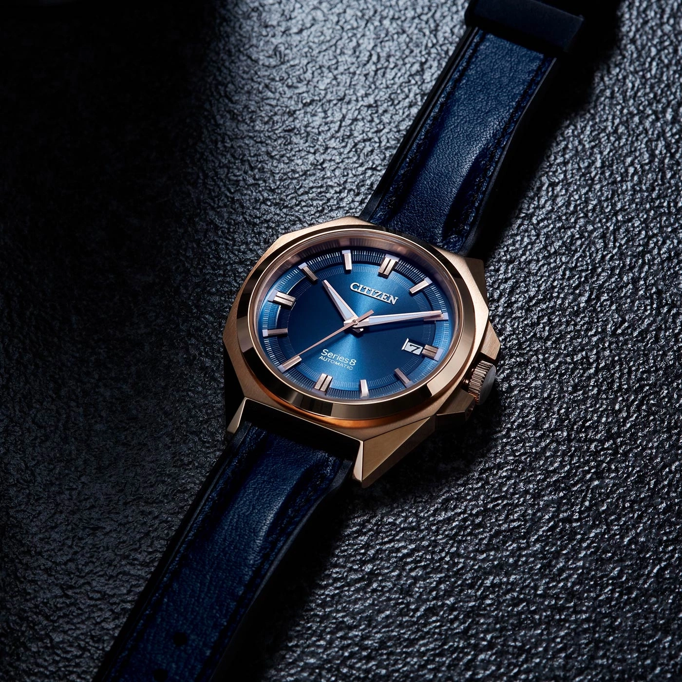 Citizen horloge met blauwe wijzerplaat en leren band op een getextureerd oppervlak