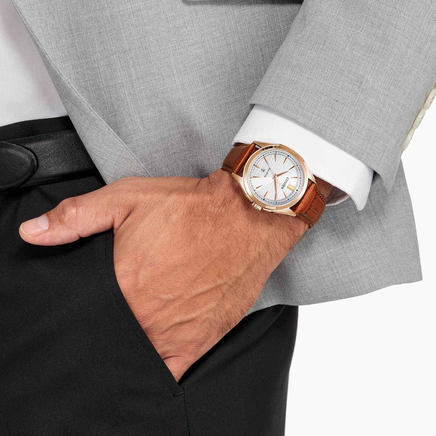 Man met horloge, pak en hand in zak. Elegant en stijlvol.