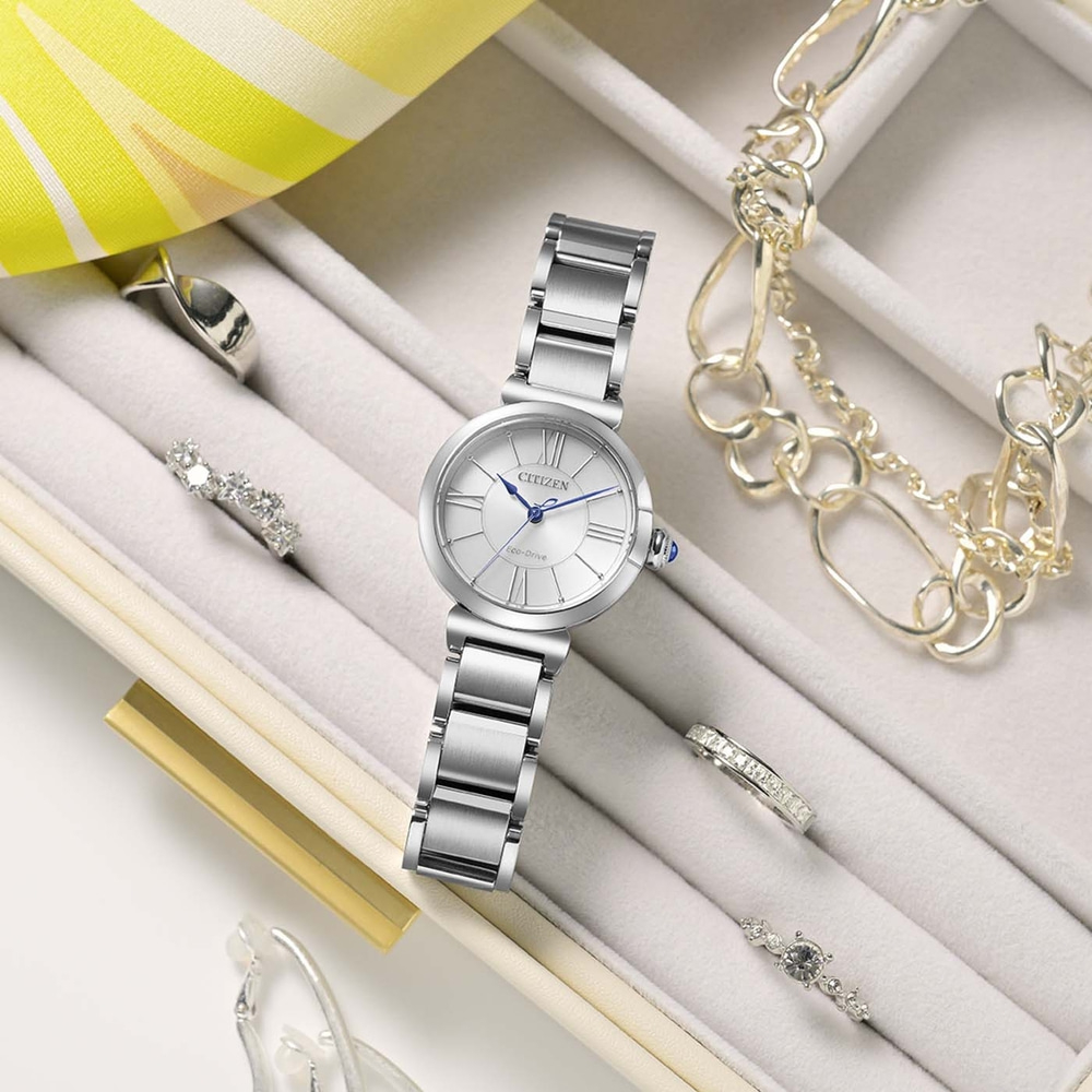 Een zilveren Citizen Eco-Drive horloge met ringen en armbanden in een juwelendoosje.