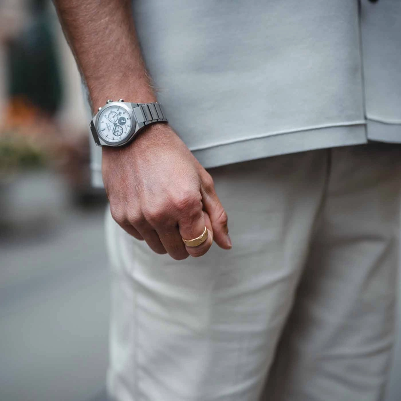 Man met horloge en gouden ring, close-up van zijn hand en kleding.
